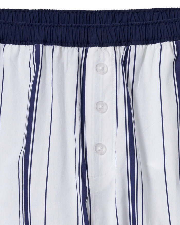Close-up of Women’s Poplin Romy Pants in Parlor Stripe, featuring white fabric with vertical navy blue stripes, a navy blue elastic waistband, and a button fly with four white buttons.