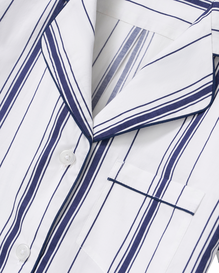 Close-up of the Women’s Poplin Short Sleeve Short Set in Parlor Stripe, featuring a white shirt with navy blue vertical stripes, white buttons, a notched collar, and a chest pocket. The poplin fabric appears smooth and lightweight.