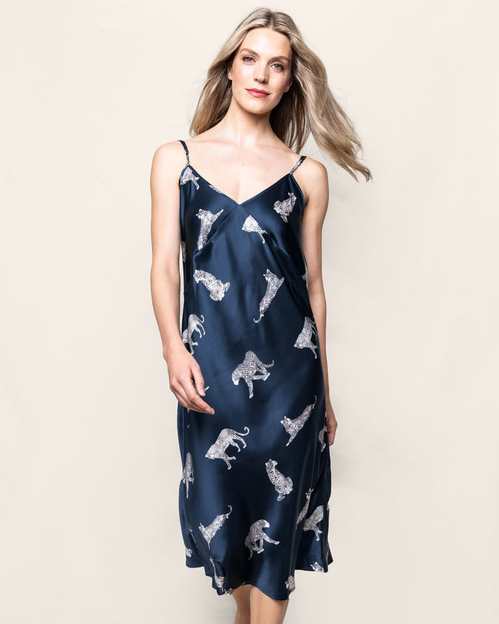 A woman models the Womens Silk Cosette Nightgown in Panthère de Nuit by Petite Plume. Her long, light brown hair flows as she approaches the camera against a plain background, showcasing the elegance of this luxury sleepwear.