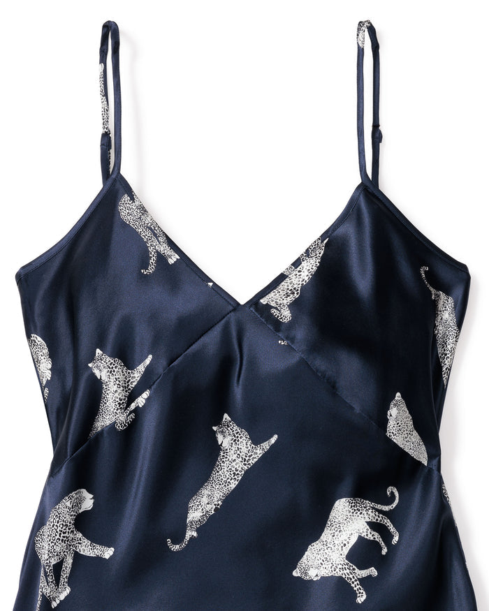 The Petite Plume Womens Silk Cosette Nightgown in Panthère de Nuit is a luxurious dark blue camisole with thin straps, adorned with white leopards. Made from mulberry silk, it offers a silky feel and subtle shine, perfect for luxury sleepwear.