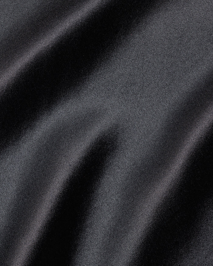 Close-up of Petite Plumes Womens Silk Lace Robe in Black, with smooth, flowing folds reminiscent of luxurious mulberry silk. The materials sheen casts subtle highlights and shadows, adding depth and a sense of movement to the texture.