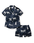 A women's silk short set in navy with a white animal print, featuring a button-up top and matching shorts with a elastic waistband.
