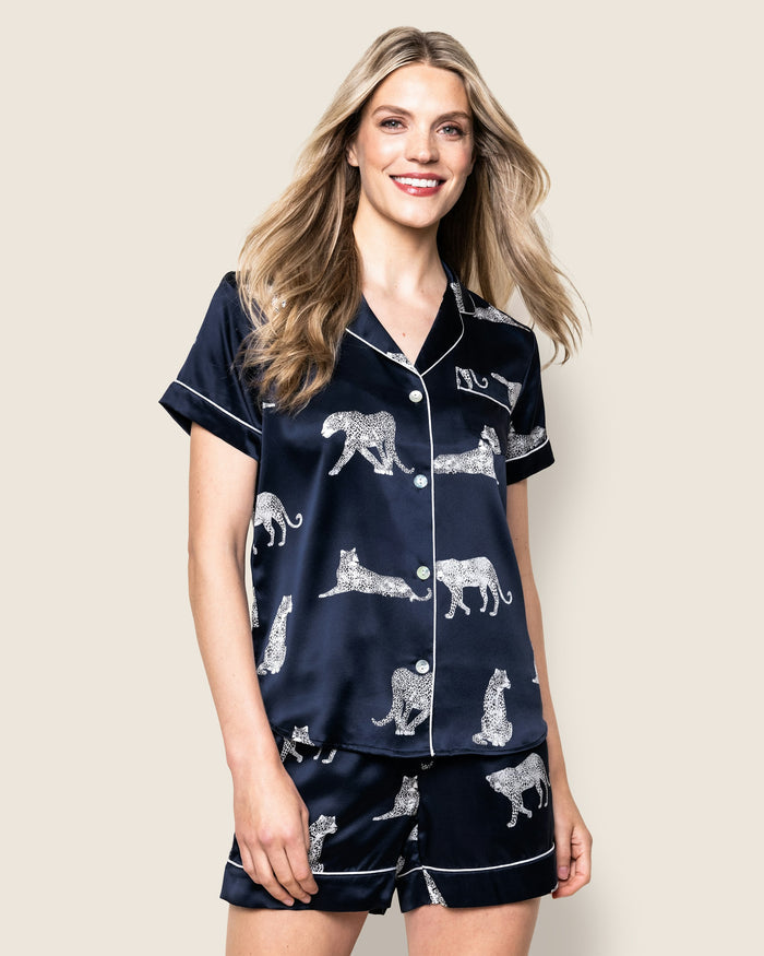 A women's silk short set in navy with a white animal print, featuring a button-up top and matching shorts with a elastic waistband.