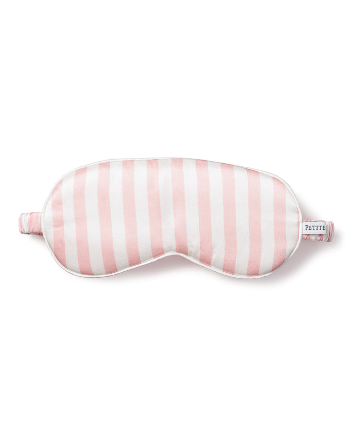 The Womens Silk Sleep Mask in Pink Stripe from Petite Plume features a cushioned design for luxurious comfort and a PETITE label on its strap, enhancing your rest.