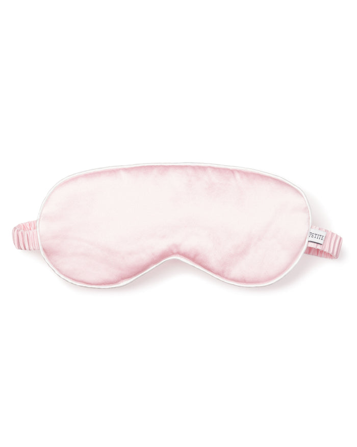 The Womens Silk Sleep Mask in Pink by Petite Plume features a soft, cushioned texture and a striped elastic strap, crafted from pure silk for ultimate comfort.
