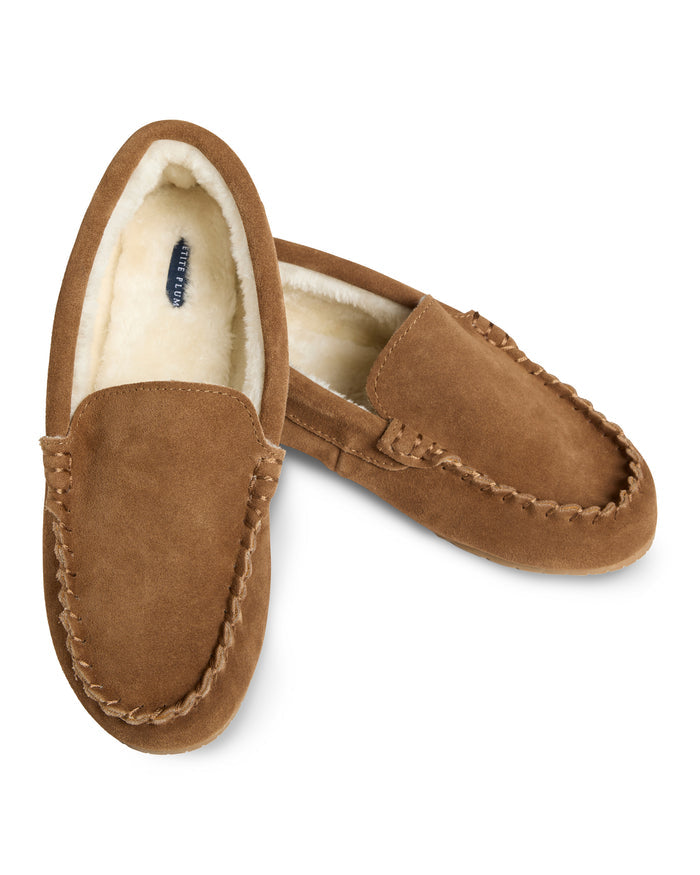 Petite Plumes Womens Suede Slippers in Tan feature ultra-soft suede with visible stitching and a luxurious faux fur lining. One slipper is laid flat while the other leans against it, showcasing the design from multiple angles.