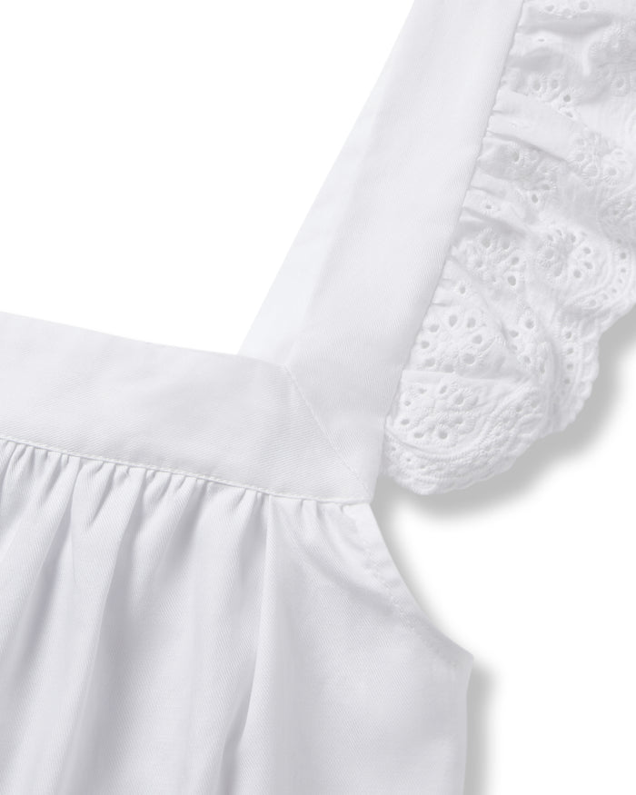 Close-up of a white garment from Petite Plume’s Womens Twill Clara Short Set, showcasing a strap with lace ruffle detail. This luxurious cotton sleepwear is soft and neatly tailored to emphasize the intricate lace pattern on the strap.
