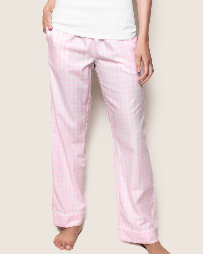 A person is standing barefoot, showcasing the soft cotton Womens Twill Pajama Pants in Pink Gingham by Petite Plume against a neutral background. The image is cropped from the shoulders down.