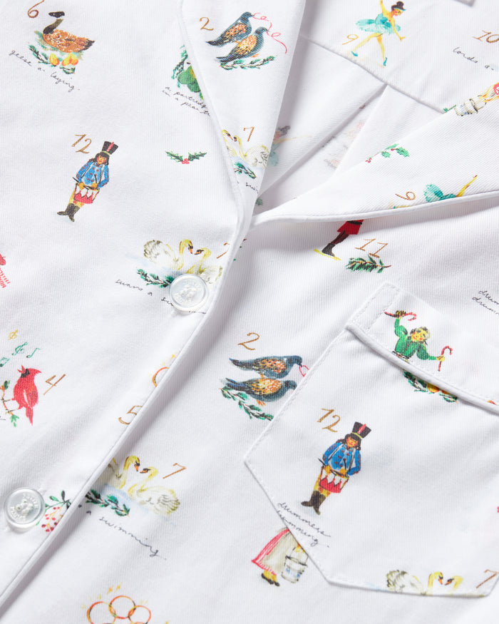 Women's Twill Pajama Set in 12 Days of Christmas features a white button-up long sleeve top and pants, adorned with a playful pattern of multicolored animals and palm trees.