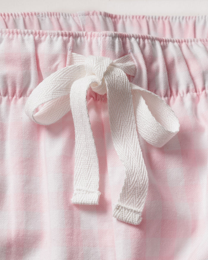 Women's Twill Pajama Set in Pink Gingham features a long-sleeve button-up top with a chest pocket and matching drawstring pants, shown laid flat on a white background.