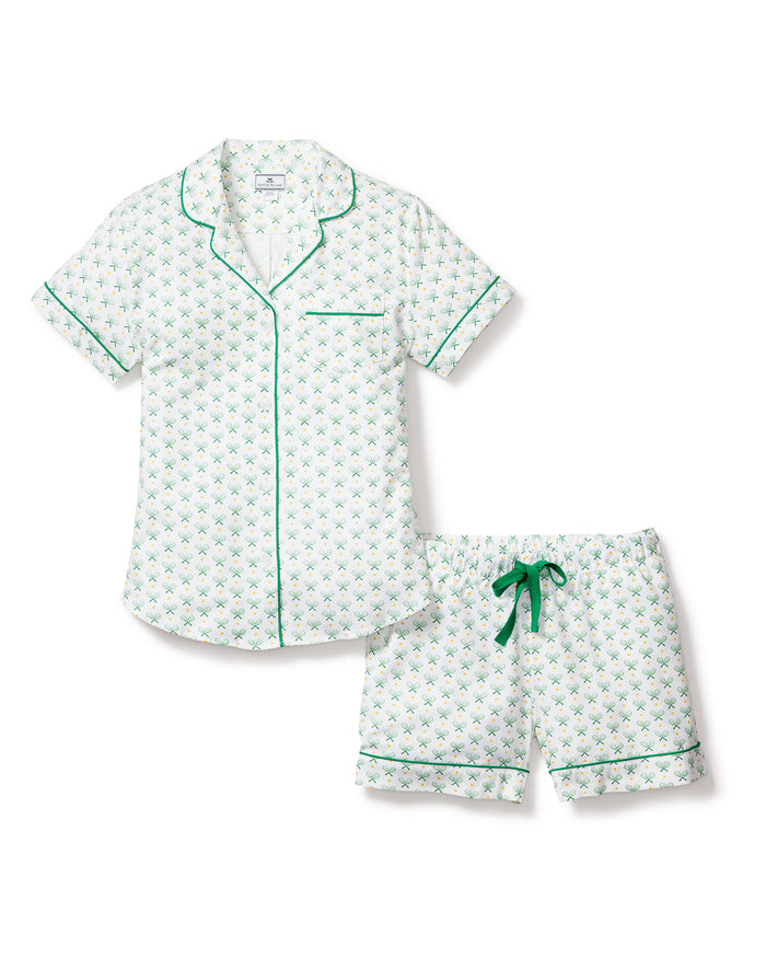 Elevate your nights with Petite Plumes Womens Twill Pajama Set in Match Point. This luxurious white cotton sleepwear features a green floral pattern, a short-sleeve button-up shirt with green piping and chest pocket, and matching shorts with a drawstring and piped hem.