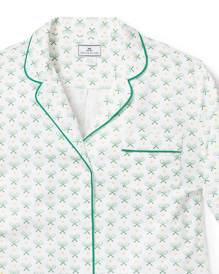 Close-up of the Womens Twill Pajama Short Sleeve Short Set in Match Point by Petite Plume, featuring a green and gold tennis racket and ball pattern. These luxury pajamas have dark green piping on the collar, pocket, and buttons, with Petite Plume labeled inside for style and comfort.