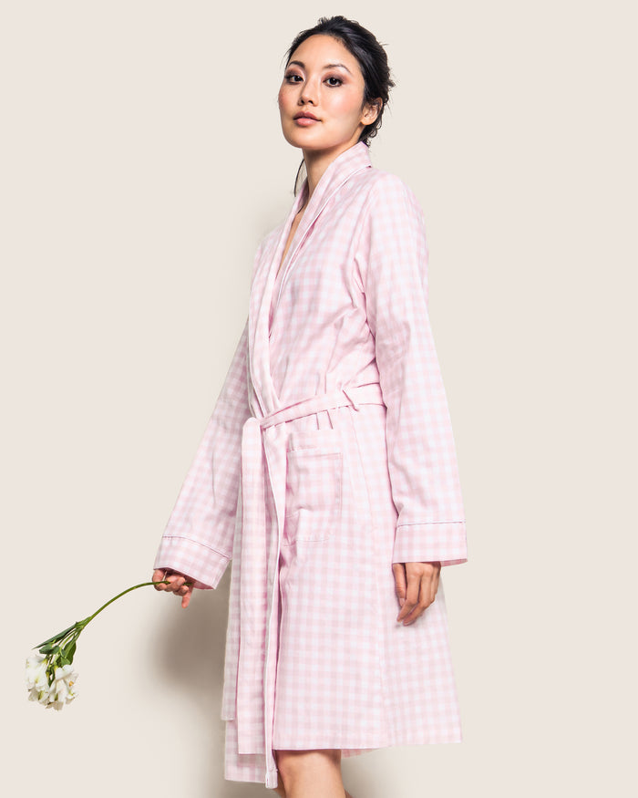 The Women's Twill Robe in Pink Gingham features long sleeves, a shawl collar, front pockets, and a matching fabric belt at the waist, shown laid flat on a white background.
