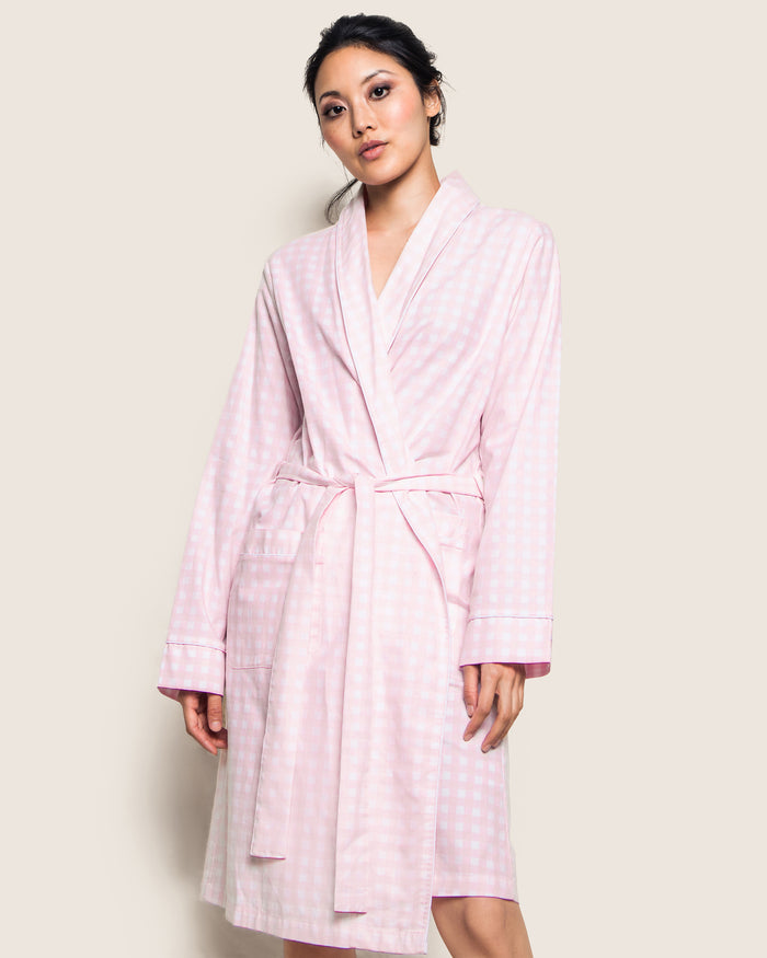 The Women's Twill Robe in Pink Gingham features long sleeves, a shawl collar, front pockets, and a matching fabric belt at the waist, shown laid flat on a white background.