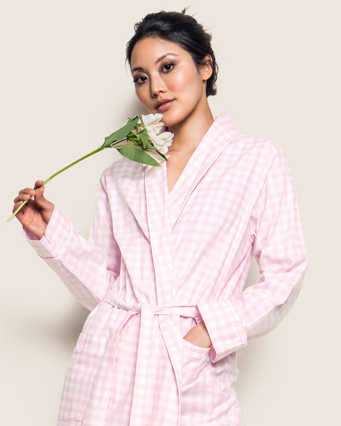 The Women's Twill Robe in Pink Gingham features long sleeves, a shawl collar, front pockets, and a matching fabric belt at the waist, shown laid flat on a white background.