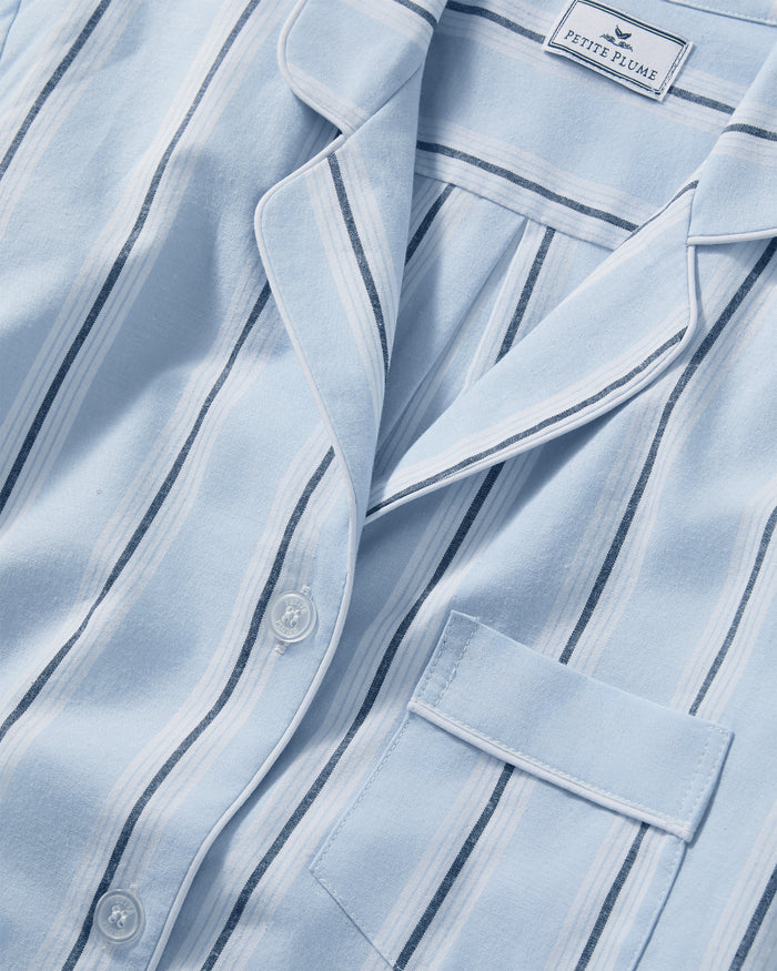 Close-up of the Women’s Twill Short Sleeve Short Set in Coastal Stripe, featuring light blue, white, and navy stripes with white piping, a chest pocket, white buttons, and a Petite Plume label on the collar.
