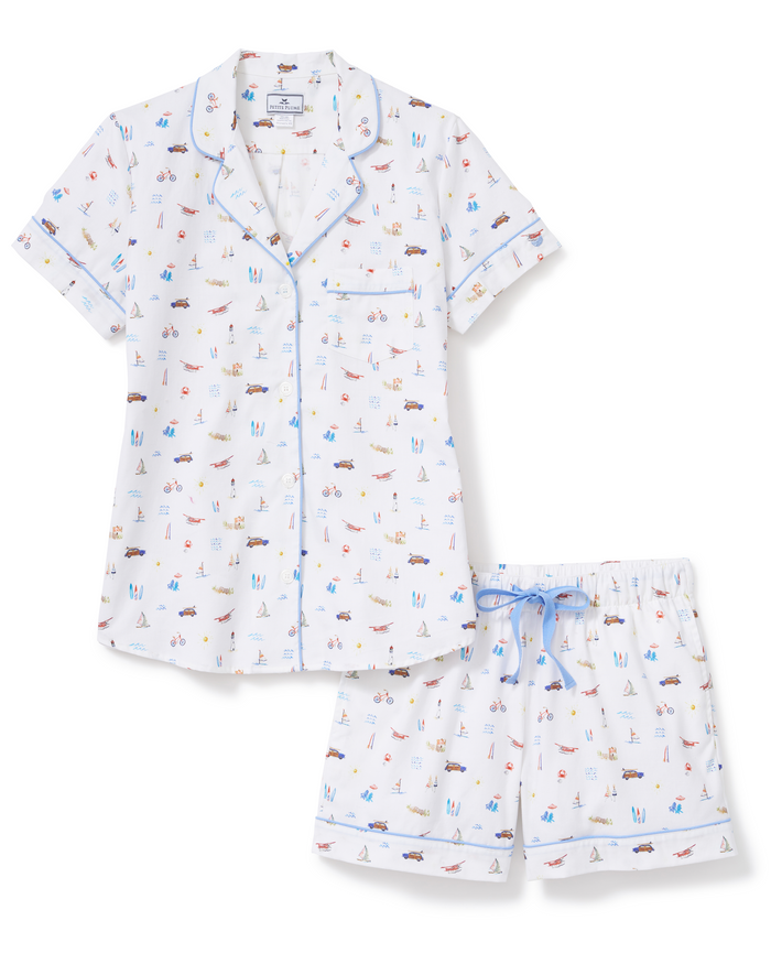 Women’s Twill Short Sleeve Short Set in Summer Nostalgia: A short-sleeve pajama set with a button-up shirt and shorts, featuring a playful print of cars, boats, and beach scenes on crisp white fabric, accented with light blue piping.