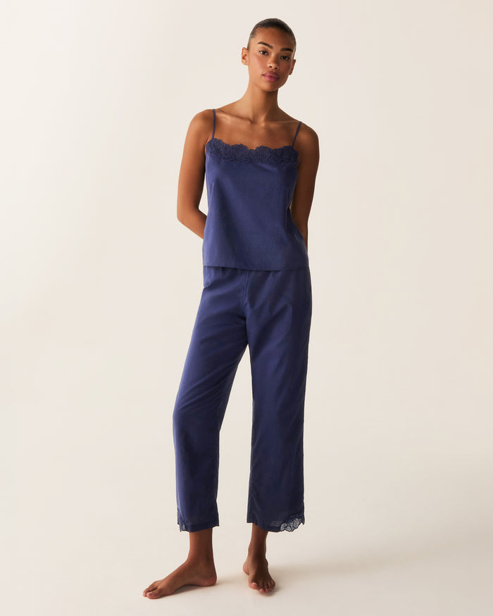 A woman stands barefoot against a plain light background, wearing the Women's Voile Fleur Cami Pant Set in Navy.