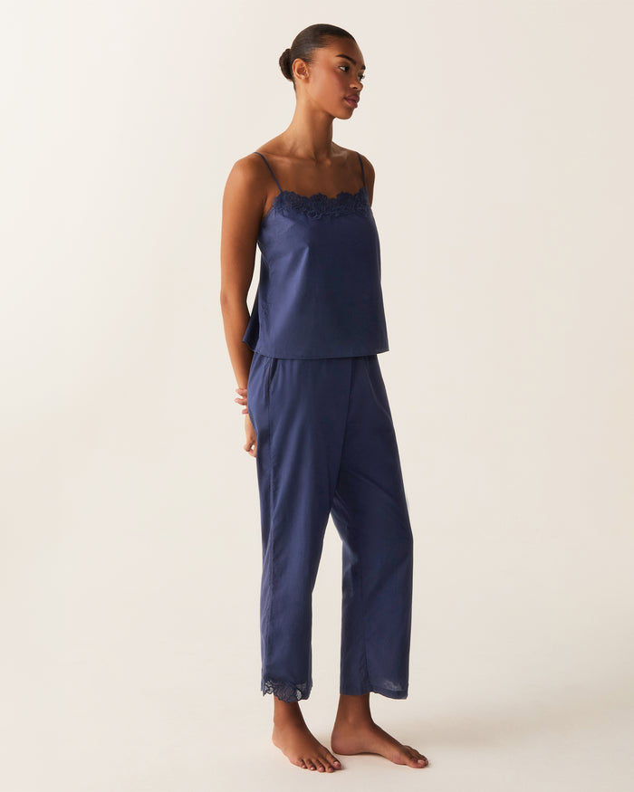 A woman stands barefoot against a plain light background, wearing the Women's Voile Fleur Cami Pant Set in Navy.