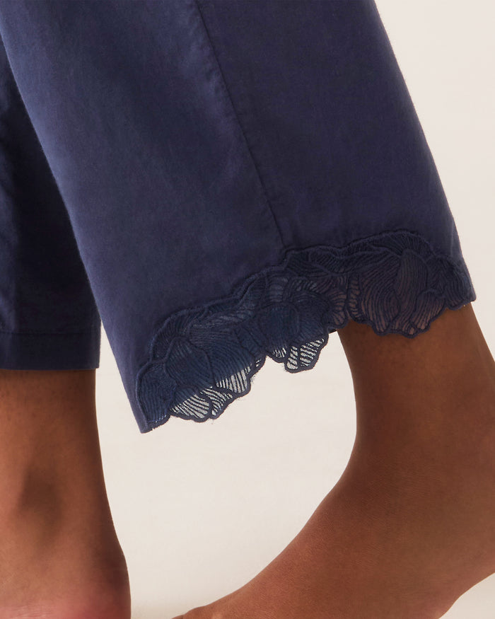 A woman stands barefoot against a plain light background, wearing the Women's Voile Fleur Cami Pant Set in Navy.